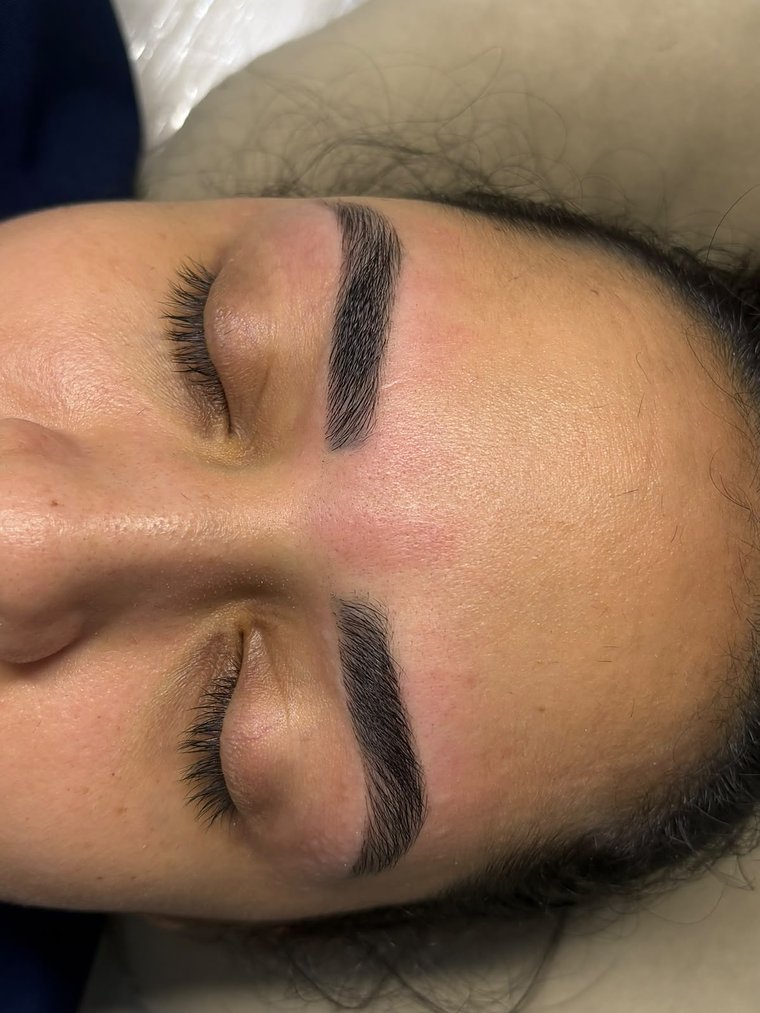 Cliente de olhos fechados com sobrancelhas desenhadas e cílios naturais